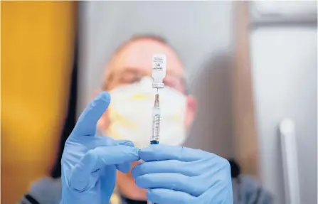  ?? NOAH BERGER/AP ?? A pharmacist draws saline while preparing a dose of COVID-19 vaccine last week in Sacramento, Calif. Virus mutations are causing concern.