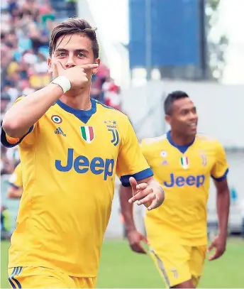  ?? FILE ?? Juventus’ Argentinia­n striker Paulo Dybala celebrates after scoring during a Serie A match between Sassuolo and Juventus, at Mapei Stadium in Reggio Emilia, Italy recently. Dybala’s teammate, Brazilian Alex Sandro looks on.