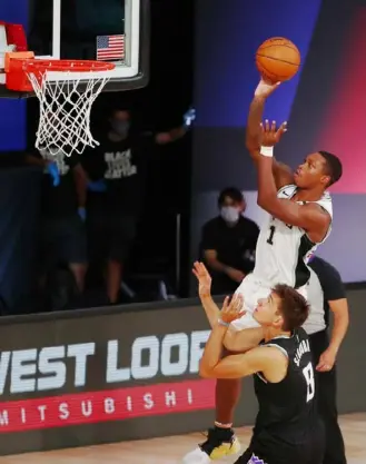  ?? Kim Klement/Getty Images ?? San Antonio’s Lonnie Walker IV shoots over Sacramento’s Bogdan Bogdanovic in the first half of the Spurs’ 129-120 win Friday in Lake Buena Vista, Fla.