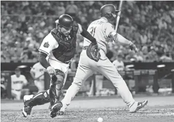  ??  ?? D-Backs catcher John Ryan Murphy chases down a dropped ball behind the Dodgers’ Joc Pederson on Tuesday night at Chase Field.