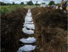  ?? AP file ?? FINAL STOP: A forensics team buries a group of 15 migrants at the Guayabillo cemetery in Agua Fria, Panama, last month. The migrants died while crossing the Darien jungle trying to make their way to the United States.