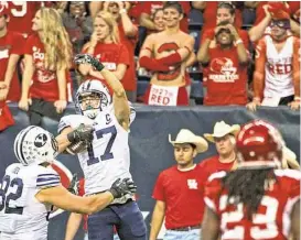  ??  ?? UH fans were dismayed when BYU’s Skyler Ridley (17), celebratin­g with Kaneakua Friel, caught the go-ahead touchdown pass with 1:08 remaining.