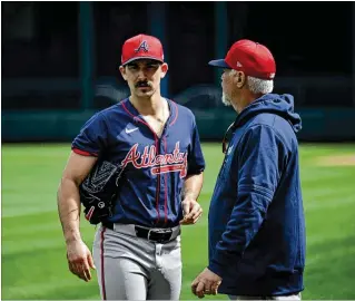  ?? HYOSUB SHIN/HYOSUB.SHIN@AJC.COM ?? Spencer Strider (left) confers with pitching coach Rick Kranitz at a Braves spring training workout in North Port, Fla. Kranitz on Strider’s curveball: “It will affect the timing of the hitter. There’s a lot of hitters (that), obviously when you throw so hard, they just sit hard.”