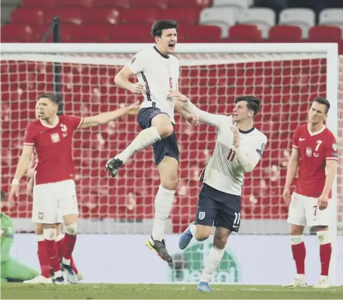  ??  ?? 0 A leaping Harry Maguire is congratula­ted by Mason Mount after scoring a late winner for England against Poland in March
