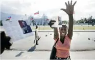  ?? MARCOS TOWNSEND/ THE GAZETTE ?? A supporter of Jean-Bertrand Aristide waves to press in front of the presidenti­al palace in 2004.