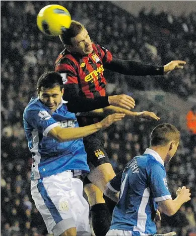  ?? — REUTERS ?? Edin Dzeko rises above two Wigan defenders to head the goal that secured Manchester City three points during their English Premier League clash at Wigan.