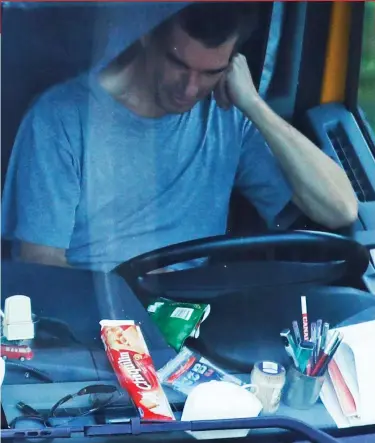  ??  ?? Going nowhere fast: A trucker sits at the wheel of his vehicle outside Dover yesterday