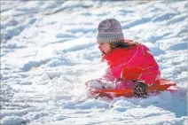  ??  ?? Lila Petronzi, 4, whooshes down a snow-covered hill Monday at Fox Hill Park in Summerlin.