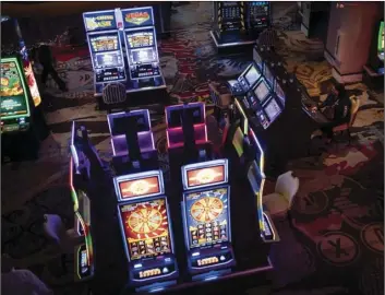  ?? AP PHOTO/WONG MAYE-E ?? In this Nov. 8, 2020, file photo, a woman sits at a slot machine in a casino in Las Vegas.