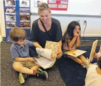  ?? ROBERT NOTT/THE NEW MEXICAN ?? Alicia Sanchez reads to her son, Joey Lee, on the first day Monday of pre-kindergart­en at Tesuque Elementary School.