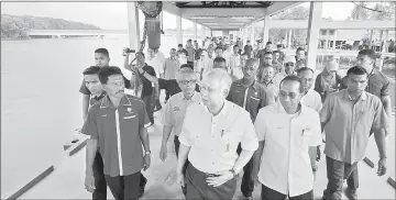  ??  ?? Najib (second left) visiting a jetty after speaking at a gathering with the local community in Kampung Nenasi Pantai. — Bernama photo