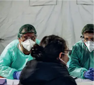  ??  ?? Ospedale Civile Medici al lavoro nella tenda del pre triage (Imagoecono­mica)