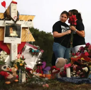  ?? JOE RAEDLE/GETTY IMAGES ?? Alexa and Heather Mesch pay tribute to the 17 people killed at Marjory Stoneman Douglas High School. The provincial nature of the U.S. may explain how Second Amendment advocates ignore global evidence that gun control works, Rick Salutin writes.