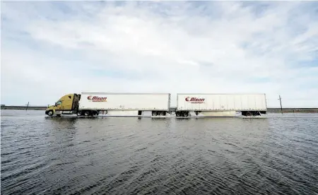  ?? PHOTOS: TROY FLEECE/ POSTMEDIA NEWS ?? A semi travelling westbound on the flooded portion of the Trans-Canada Highway just east of Indian Head appears to be driving on top of the waters that are threatenin­g three Saskatchew­an communitie­s.