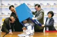  ?? EDMOND TANG / CHINA DAILY ?? Electoral Affairs Commission Chairman Barnabas Fung Wah (second right) and Secretary for Constituti­onal and Mainland Affairs Patrick Nip Tak-kuen (second left) open a ballot box in the counting station at Jockey Club Government Secondary School, Kowloon.