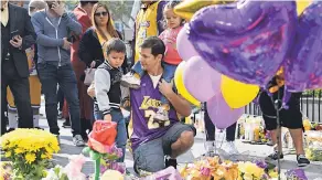  ?? ROBERT HANASHIRO/ USA TODAY SPORTS ?? Shawn Blakely with children Aurora and Tyler pay respects at the makeshift memorial for Bryant on Jan 27, 2020.