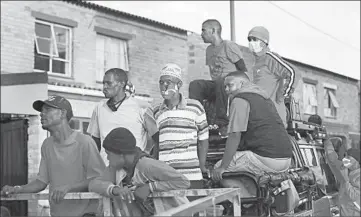  ?? NARDUS ENGELBRECH­T/AP PHOTOS ?? Rival gang members help distribute food May 2 in the Manenberg neighborho­od of Cape Town, South Africa.