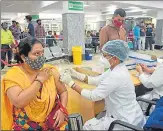  ?? DEEPAK GUPTA/HT PHOTO ?? (Left) District-wise vaccinatio­n figures and (right) a beneficiar­y taking the jab during the mega vaccinatio­n drive in Lucknow at Balrampur Hospital on Monday.