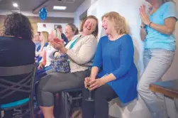  ?? EDDIE MOORE/JOURNAL ?? Kate Diaz, left, the principal at Atalaya Elementary, laughs with Gail Ansheles, a kindergart­en teacher at El Dorado Community School, as they watch Ansheles compete on the “Jeopardy!” TV game show at a watch party in Santa Fe on Monday. Ansheles won...