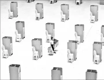  ?? — AFP photo ?? A worker assembles voting booths at a polling station in Cali, Colombia.