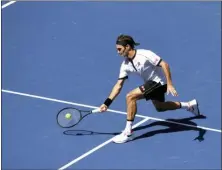  ?? SARAH STIER — THE ASSOCIATED PRESS ?? Roger Federer returns a shot to Daniel Evans during round three of the US Open on Friday in New York.