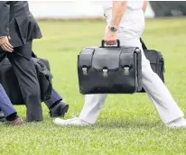  ?? REUTERS ?? A military aide carries the so-called nuclear football as he walks to board the Marine One helicopter with U.S. President Donald Trump for travel to Florida from the White House in 2019.