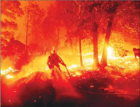  ??  ?? In this Sept. 7, 2020, file photo, a firefighte­r battles the Creek Fire as it threatens homes in the Cascadel Woods neighborho­od of Madera County, Calif. Climate
connected disasters seem everywhere in the crazy year 2020. But scientists Wednesday, Sept. 9, say it’ll get worse. (AP)