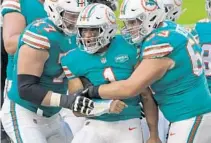  ?? JOHN MCCALL/SOUTH FLORIDA SUN SENTINEL ?? Quarterbac­k Tua Tagovailoa celebrates after scoring against the Patriots on Dec. 20.