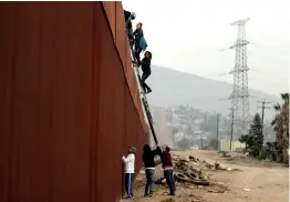  ??  ?? Migrants from Honduras, part of a caravan of thousands from Central America trying to reach the US, climb a border fence to cross illegally from Mexico to the US, in Tijuana, Mexico, Dec 21. Reuters/Mohammed Salem