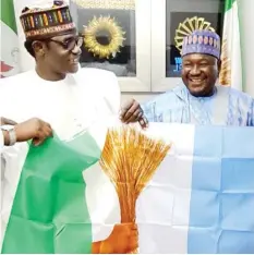  ??  ?? Yobe Gov. and Chairman APC Caretaker Committee Hon. Mai Mala Buni (left) presenting the party's flag to Sen. Isah. Hamma Misau Bauchi State, who defected from PDP to APC