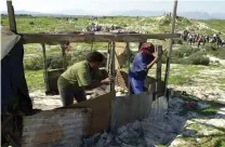  ?? Picture: Independen­t Media Archives ?? DESPERATE: A landless woman builds a shack on state-owned land next to the new bridge in Khayelitsh­a.