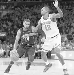  ?? KATHY WILLENS/ASSOCIATED PRESS ?? Magic guard D.J. Augustin gets entangled with Knicks forward Lance Thomas while driving to the basket during the first half Sunday at Madison Square Garden.