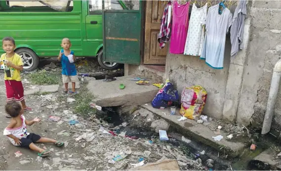  ?? SUNSTAR FOTO / ALEX BADAYOS ?? LOOK AROUND
YOU. Three children play near a dirty canal in Sitio Bugnay 2, Barangay Labangon in Cebu City. Two people, including a six-year-old boy, from Sitio Bugnay 2 have died because of dengue fever this year.