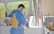  ??  ?? Josh Harris sands down a counter in a new fiberglass fishing boat that will soon be going out the door at Hutt Brothers Boat Building in Northport. Harris has been with the company for nearly 10 years.