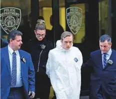  ?? AP ?? James Harris Jackson is escorted out of a police precinct in New York on Wednesday. Jackson admitted he travelled from Baltimore specifical­ly to attack black people.