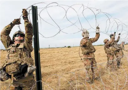  ?? DELCIA LÓPEZ/REUTERS ?? Soldados colocan alambres de púas en la frontera México-EU.