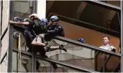  ?? Julie Jacobson / Associated Press ?? New York police officers pull a man through a window as he scaled the east side of Trump Tower using suction cups on Wednesday.