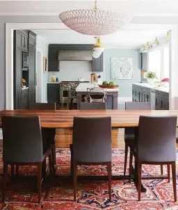  ?? Jane Beiles/ Contribute­d photo ?? The redesigned kitchen, with stained walnut cabinetry and a cabinet-free window wall, opens to the dining room to add connection and spaciousne­ss. Pops of vibrant color appear in rooms throughout the house.