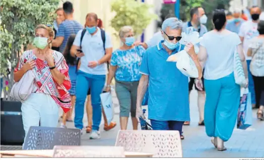  ?? ALBERTO DOMÍNGUEZ ?? Personas en la calle con mascarilla­s en plena pandemia.