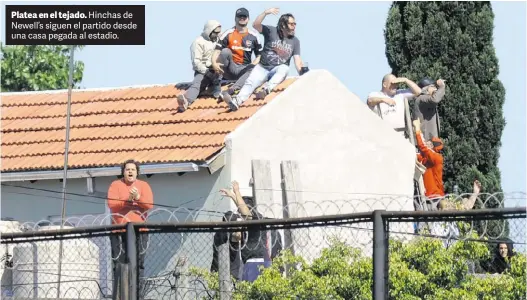  ?? JUANO TESONE ?? Platea en el tejado. Hinchas de Newell’s siguen el partido desde una casa pegada al estadio.