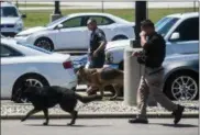  ?? JAKE MAY — THE FLINT JOURNAL-MLIVE.COM (VIA AP) ?? Police dogs search cars in a parking lot at Bishop Internatio­nal Airport, Wednesday morning in Flint, Mich.