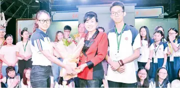  ??  ?? A student representa­tive from Wuyi University presents Wong with a bouquet of flowers in appreciati­on for the dinner the latter hosted.