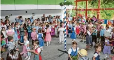  ?? Foto: Claus Braun ?? Unter den stolzen Blicken von Eltern, Großeltern und Geschwiste­rn tanzen die Kinder beim Schulfest in Thierhaupt­en um einen Maibaum.