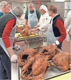  ?? PAT A. ROBINSON / MILWAUKEE JOURNAL SENTINEL ?? Chef Bob Ilk (second from right) trains volunteers on deboning turkeys Friday as the crew prepares for the Salvation Army Christmas Family Feast.