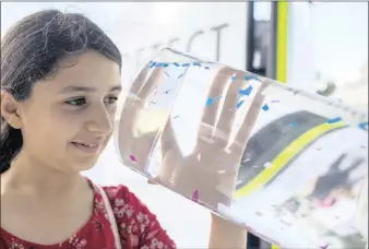  ?? PICTUTRE: THE WASHINGTON POST ?? Nikasha Kapadia, 12, looks at small plastic particles in a hands-on part of the exhibit.