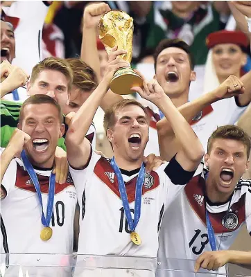  ?? AP ?? In this July 13, 2014, file photo, Germany’s Philipp Lahm (16) raises the trophy after the World Cup final between Germany and Argentina at the Maracana Stadium in Rio de Janeiro, Brazil.