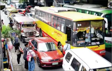  ?? TED ALJIBE/AFP ?? Commuters wait for their ride along a main road in Manila on Tuesday.