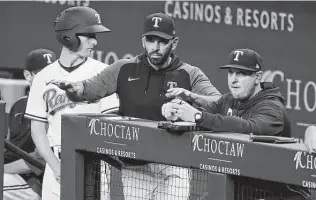  ?? Tony Gutierrez / Associated Press ?? Manager Chris Woodward, center, doesn’t want to see the Rangers continue their poor defensive trend heading into the upcoming All-star break, saying it “will be addressed.”