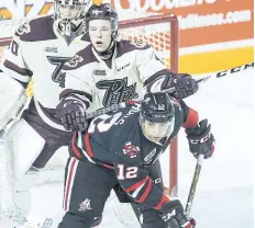  ??  ?? Niagara IceDogs Akil Thomas (12) is checked by Peterborou­gh Petes Matthew Timms (4) in OHL hockey action Feb. 3 at the Meridian Centre in St. Catharines.