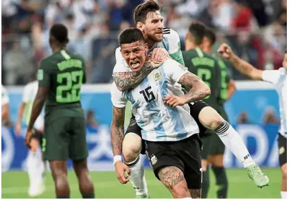  ?? — Reuters ?? He ain’t heavy: Argentina’s Lionel Messi hugging Marcos Rojo after the defender scored the winner against Nigeria in the Group D match at the Saint Petersburg Stadium on Tuesday.